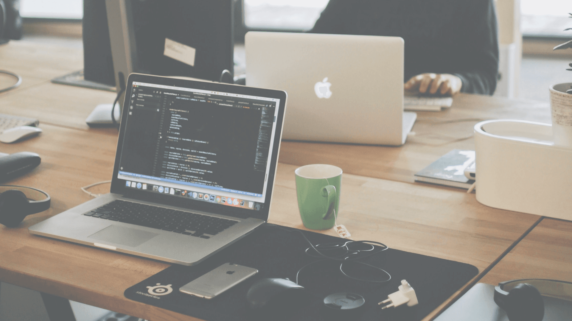 Open laptop in office environment with code on screen